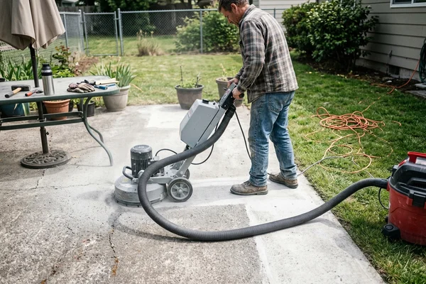 Walk-behind grinder lightly opening a concrete patio surface before sealing